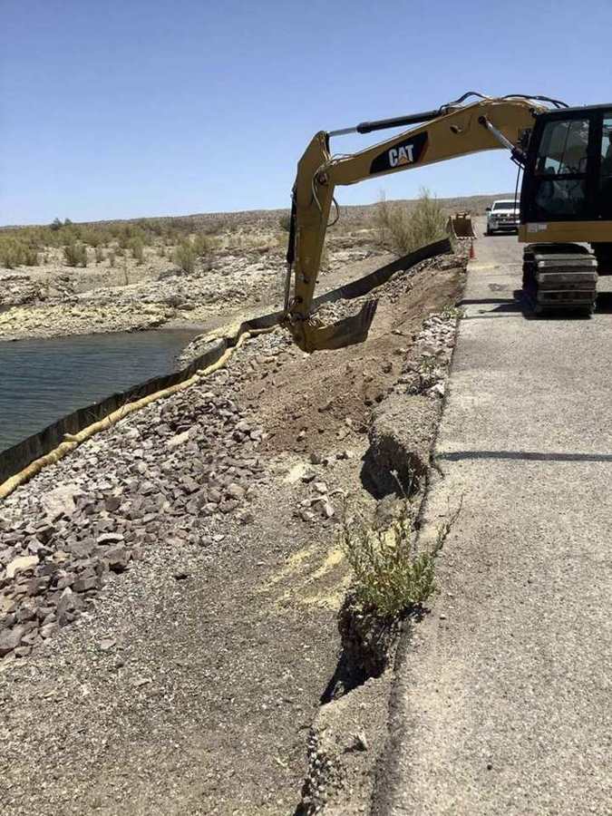 Excavator rebuilding an eroded shoreline along the park road
