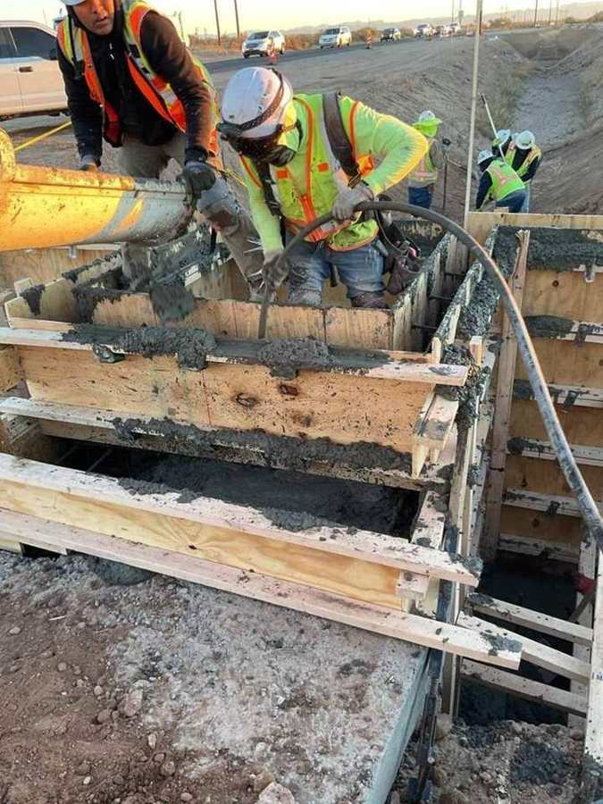 Crew consolidating concrete in structure forms