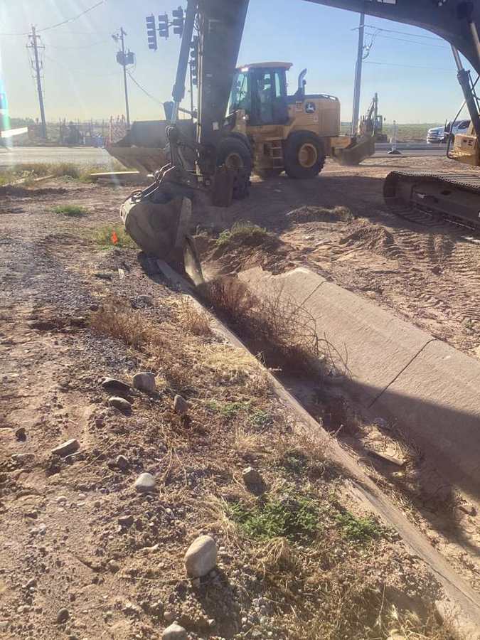 Excavator removing old curb and gutter