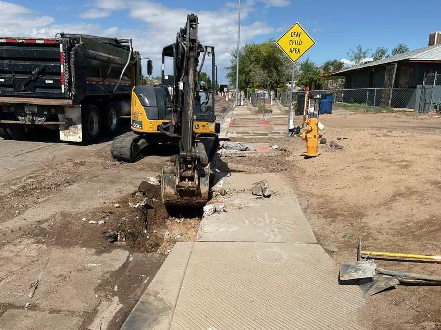 Mini excavator removing curb and gutter