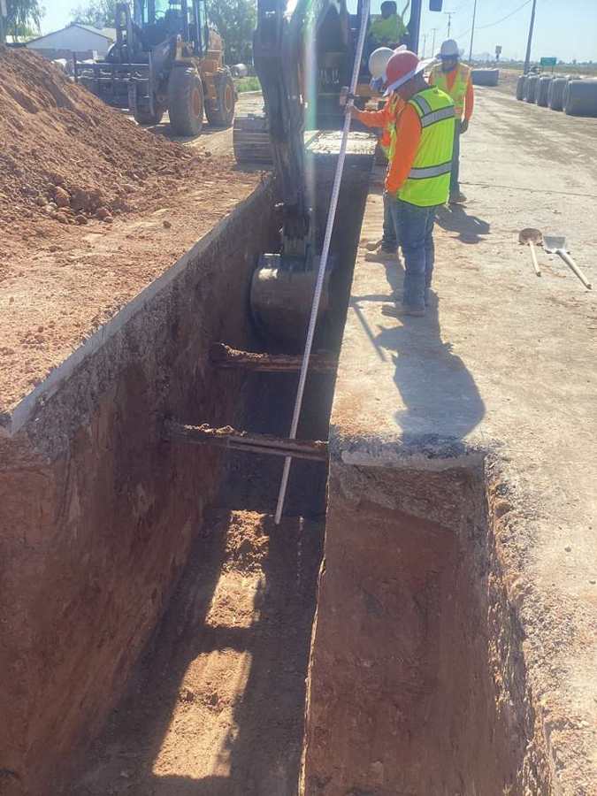 Crew checking trench grade from topside