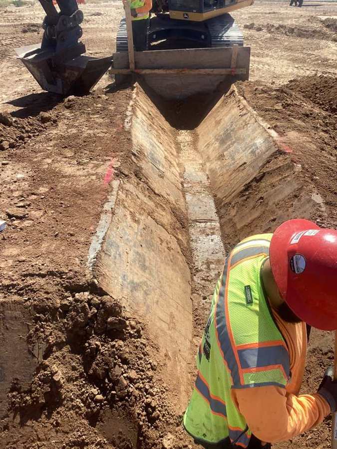 Shaping an irrigation ditch with a template bucket