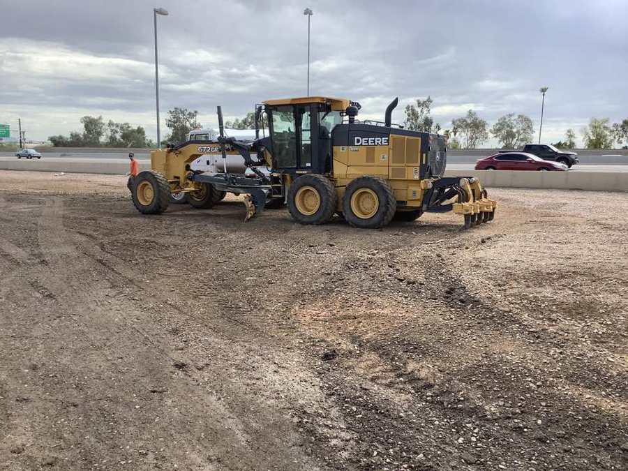 Motor grader cutting subgrade along the freeway