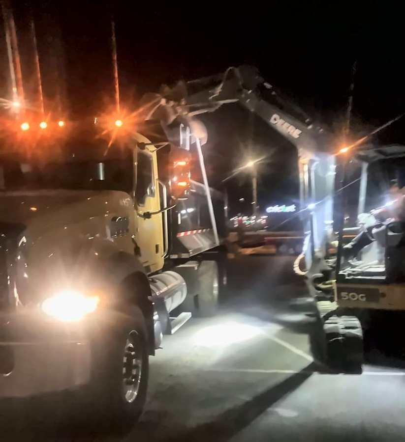 Excavator loading a dump truck on a night shift
