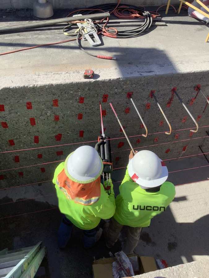 Crew epoxy-doweling rebar into a channel wall