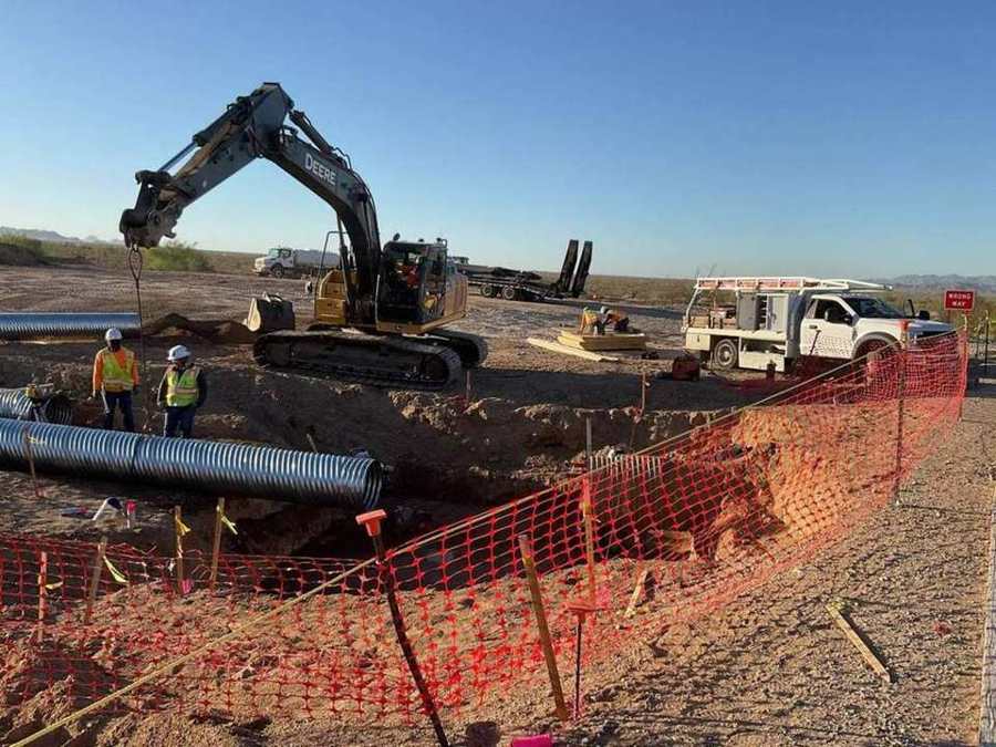 Excavator setting storm pipe