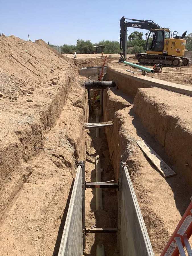 Shored sewer trench with spreaders