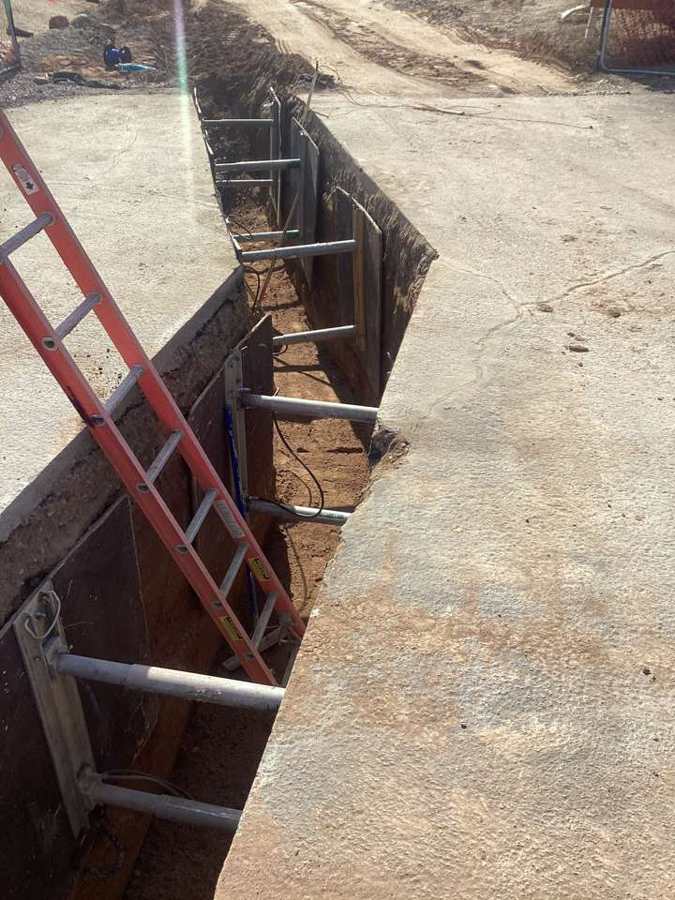 Hydraulic shoring and ladder access on a water line trench
