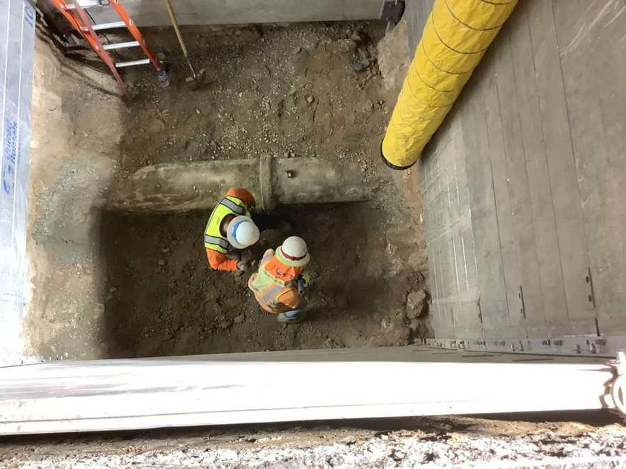Crew working in a shored excavation with forced-air ventilation