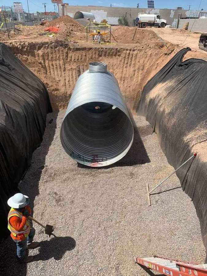 Corrugated metal retention pipe on rock bedding